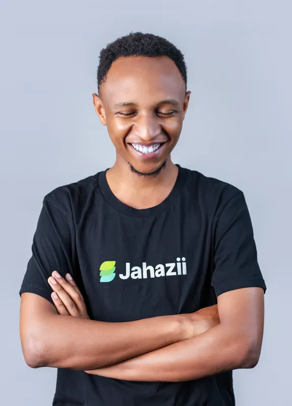 Lewis laughing with his arms crossed, wearing a black Jahazii T-shirt