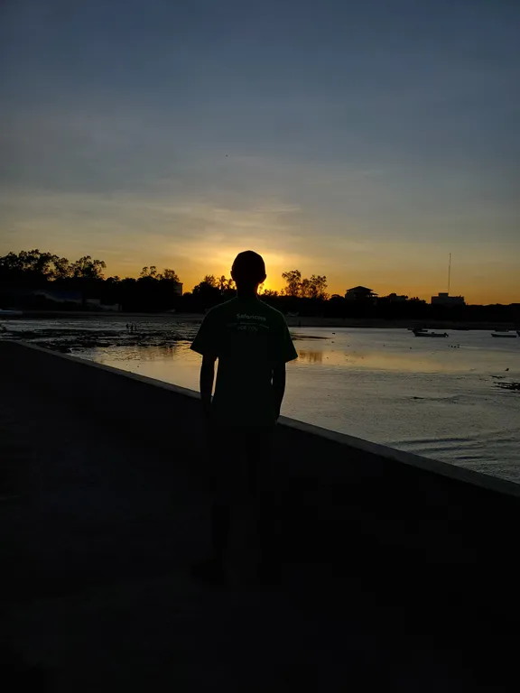 Silhouette of Lewis watching the sunset over the water in Malindi