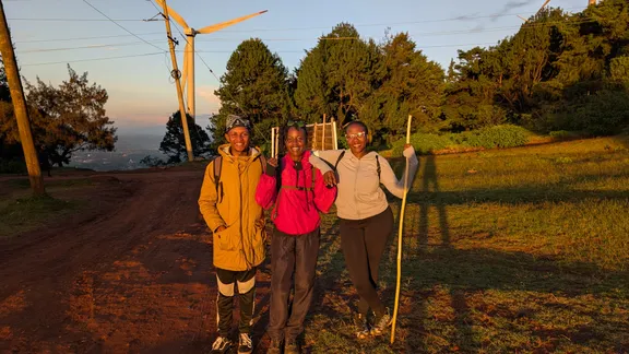 Lewis and two friends in golden evening light by the wind turbines on the Ngong Hills